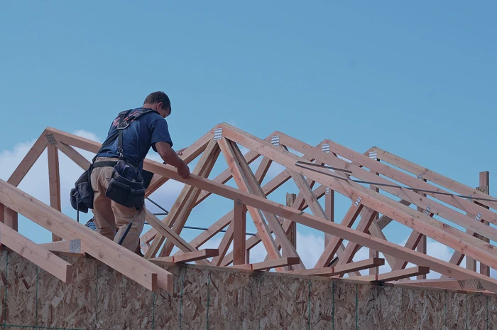 Charpentier travaillant sur le toit d'une maison