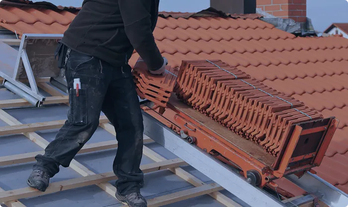 Artisan couvreur sur toit avec tuiles