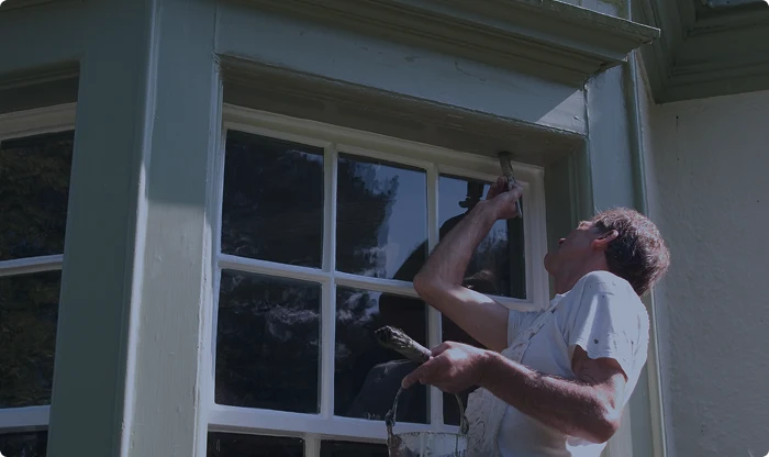 Artisan couvreur peignant bord de fenêtre